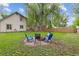 Spacious backyard featuring a fire pit with chairs and a large, mature tree providing ample shade at 32 Powder Horn Pl, Longmont, CO 80504
