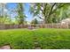 A large, grassy backyard has a fire pit and a tall wooden fence at 32 Powder Horn Pl, Longmont, CO 80504