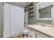 Bathroom with a white shower curtain, stylish sink, and decorative shelves at 32 Powder Horn Pl, Longmont, CO 80504