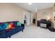 Bedroom features light grey carpet, a blue sofa, and access to ensuite bathroom at 32 Powder Horn Pl, Longmont, CO 80504