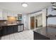 Well-lit kitchen features gray cabinets, stainless steel appliances, and sliding glass door to backyard at 32 Powder Horn Pl, Longmont, CO 80504