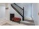 Hallway staircase with black banister and wood accent storage bench at 32 Powder Horn Pl, Longmont, CO 80504