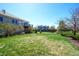 Large backyard with lush lawn, mature trees, and a raised deck at 11606 Sagewood Ln, Parker, CO 80138