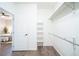 Walk-in closet with white shelving, hanging rods, and hardwood flooring at 11606 Sagewood Ln, Parker, CO 80138