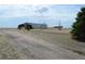 A long metal barn sits in a field on a ranch with clear blue skies overhead at 74500 E 136Th Ave, Byers, CO 80103