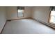 Simple bedroom with neutral carpet, baseboard heating, and windows with patterned valances at 74500 E 136Th Ave, Byers, CO 80103
