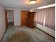 Bright bedroom with gray walls, wood trim, window, soft curtains and a dark wood armoire for storage at 74500 E 136Th Ave, Byers, CO 80103