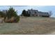 A two-story tan home with a white fence sits on a hill on this property at 74500 E 136Th Ave, Byers, CO 80103