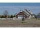 Side view of a home with a brick-facade garage and a white garage door at 74500 E 136Th Ave, Byers, CO 80103