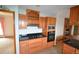 Open-concept kitchen with granite countertops, stainless steel appliances, and wood cabinets at 74500 E 136Th Ave, Byers, CO 80103