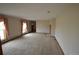 Spacious living room featuring large windows with pink curtains and neutral carpet at 74500 E 136Th Ave, Byers, CO 80103