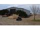 View of the outbuilding with an oversized door and tractor parked outside on a large lot at 74500 E 136Th Ave, Byers, CO 80103