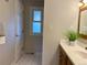 Bright bathroom with a white tile floor, white sink with wooden cabinet, and natural light window at 6272 S Garfield Dr, Centennial, CO 80121