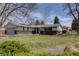 Charming single-story home with a well-maintained lawn and mature trees under a bright, blue sky at 6272 S Garfield Dr, Centennial, CO 80121