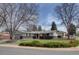 Exterior shot of the home with a well-maintained front yard, brick accents, and a welcoming entrance framed by mature trees at 6272 S Garfield Dr, Centennial, CO 80121
