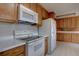 Functional kitchen featuring wood cabinets, white appliances, and durable countertops at 6272 S Garfield Dr, Centennial, CO 80121