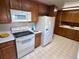 Classic kitchen with wood cabinetry, ample counter space, and bright white appliances at 6272 S Garfield Dr, Centennial, CO 80121