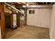 Basement utility area with water heater, furnace, and access window for maintenance or upgrades at 18121 E Adriatic Pl, Aurora, CO 80013
