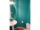 Stylish powder room with a vessel sink, modern fixtures, and vivid teal paint at 18121 E Adriatic Pl, Aurora, CO 80013