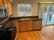 Galley kitchen showing stainless steel appliances and wood cabinets with a view to backyard at 18121 E Adriatic Pl, Aurora, CO 80013