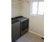 Convenient laundry room with modern, front-load washer and dryer, plus storage shelf and tile flooring at 18121 E Adriatic Pl, Aurora, CO 80013