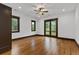 Bright bedroom with hardwood floors, windows, and a door leading to a balcony at 11790 Huckleberry Dr, Franktown, CO 80116