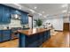 Open kitchen with a large center island, stainless hood vent, and marble backsplash at 11790 Huckleberry Dr, Franktown, CO 80116