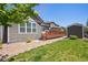 Landscaped backyard featuring a wooden deck, well-kept lawn, and storage shed at 17056 E 111Th Ave, Commerce City, CO 80022