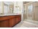 Bright bathroom features granite counters, double sinks and a glass shower enclosure at 17056 E 111Th Ave, Commerce City, CO 80022