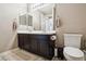 Neutral-toned bathroom boasts double sinks and a white toilet set against a tile floor at 17056 E 111Th Ave, Commerce City, CO 80022