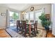 Bright dining area with a chandelier, large windows, and glass door to outdoor area at 17056 E 111Th Ave, Commerce City, CO 80022