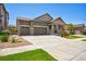 Beautiful home with a three-car garage, stone accents, a welcoming front porch, and manicured front yard at 17056 E 111Th Ave, Commerce City, CO 80022