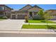 Charming two-story home featuring a three car garage, front porch, and well-maintained landscaping at 17056 E 111Th Ave, Commerce City, CO 80022