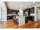 Spacious kitchen with dark wood cabinets, stainless steel appliances, granite counters, and a large center island at 17056 E 111Th Ave, Commerce City, CO 80022