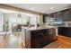 Modern kitchen featuring dark wood cabinets, granite countertops, stainless steel appliances and eat-in dining area at 17056 E 111Th Ave, Commerce City, CO 80022