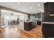Open-concept kitchen with dark wood cabinets, granite counters, stainless appliances and eat-in dining area at 17056 E 111Th Ave, Commerce City, CO 80022