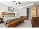 Spacious main bedroom features a ceiling fan, large bed with storage bench and walk-in closet at 17056 E 111Th Ave, Commerce City, CO 80022
