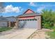 A well maintained two-car garage and driveway for a charming brick and red siding home at 7598 Jared Way, Littleton, CO 80125