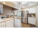 Bright eat-in kitchen with stainless steel refrigerator, light countertops, and tile floors at 7598 Jared Way, Littleton, CO 80125