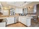 Bright kitchen with white cabinets, stainless steel appliances and convenient access to the living room and staircase at 7598 Jared Way, Littleton, CO 80125