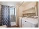 Laundry room with a shower, washer and dryer machines, shelving, and a window at 7598 Jared Way, Littleton, CO 80125