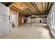 Unfinished basement featuring a new water heater, stairs, a support beam, and an egress window at 213 Washington St, Erie, CO 80516