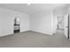 Spacious bedroom with neutral carpet, ample natural light, and a view into an ensuite bathroom at 213 Washington St, Erie, CO 80516
