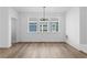 Bright dining room featuring wood floors, a modern chandelier, and lots of natural light from the three large windows at 213 Washington St, Erie, CO 80516