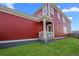 Exterior view of the home showcasing the red siding and backyard patio at 213 Washington St, Erie, CO 80516