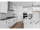 Modern kitchen with black and white backsplash, stainless steel appliances, and a center island with marble countertops at 213 Washington St, Erie, CO 80516