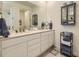 Bathroom features double vanity, blue storage cabinet, and well-lit mirror at 15919 Xanthia Way, Thornton, CO 80602