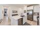 Modern kitchen features stainless steel appliances, quartz countertops, and a stylish island with seating at 15919 Xanthia Way, Thornton, CO 80602
