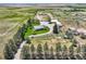 Aerial view of a sprawling farm with a well-maintained home, outbuildings, and fenced pastures, perfect for rural living at 50950 E 32Nd Ave, Bennett, CO 80102