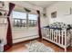 Bedroom with hardwood floors, a window with a view and wooden crib at 50950 E 32Nd Ave, Bennett, CO 80102